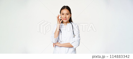 Taboo, medical confidentiality concept. Young asian doctor, female physician showing mouth silence, taboo or zip gesture, promise not tell, standing over white background Taboo, medical confidentiality concept. Young asian doctor, female physician showing mouth silence, taboo or zip gesture, promise not tell, standing over white background 114883342