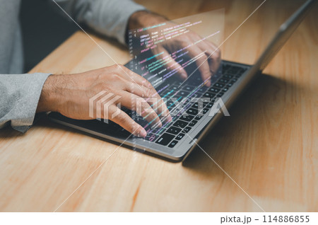 A man is typing on a laptop with a keyboard that is projected on the screen 114886855