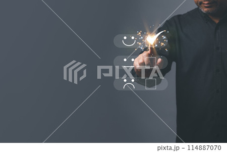 A man is pointing at a screen with a smiley face and a thumbs up 114887070