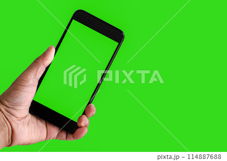 A person is holding a phone with a green screen 114887688