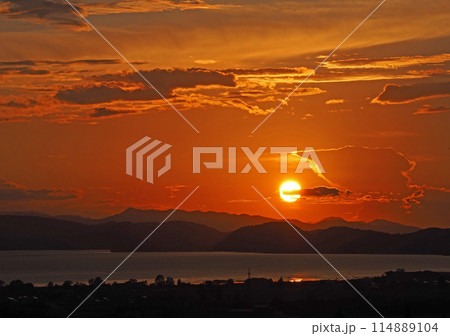 猪苗代湖対岸に沈む夕日。シルエットの山並みとオレンジ色の空に浮ぶ色々な形の雲が印象的で綺麗だ。 猪苗代湖対岸に沈む夕日。シルエットの山並みとオレンジ色の空に浮ぶ色々な形の雲が印象的で綺麗だ。 114889104