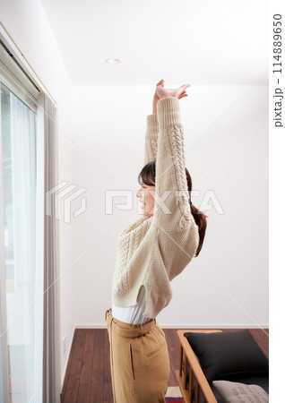 伸びをする女性　朝 114889650