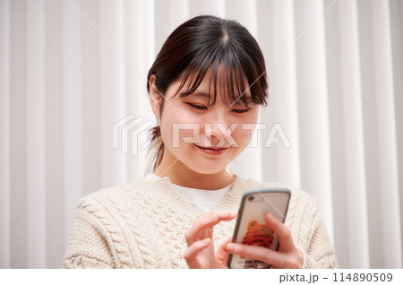 家でスマホを操作する女性 家でスマホを操作する女性 114890509