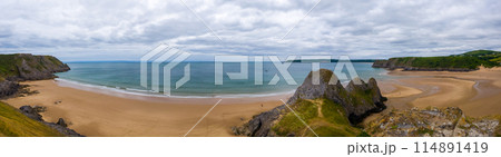 丘の上から望む干潮の砂浜のパノラマ (イギリス、ウェールズ、スリークリフス湾) 114891419