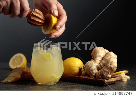 Ginger Ale with ice and lemon on a black background. 114892747