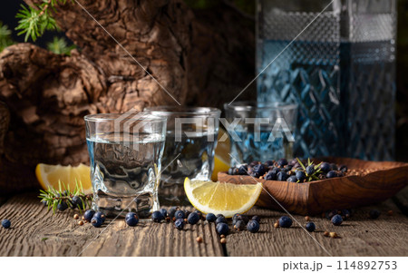 Gin with ingredients on an old wooden table. 114892753