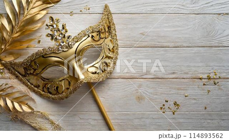Carnival party celebration concept with elegance gold mask over white wooden background Carnival party celebration concept with elegance gold mask over white wooden background 114893562
