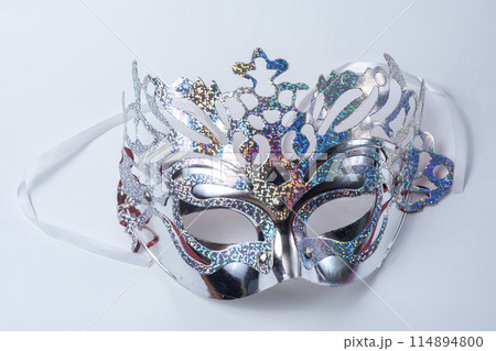 Closeup of glittering silver venetian carnival masquerade mask on white background Closeup of glittering silver venetian carnival masquerade mask on white background 114894800