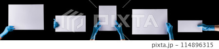 Doctor's hand in sterile medical gloves holding banner isolated on black Doctor's hand in sterile medical gloves holding banner isolated on black 114896315