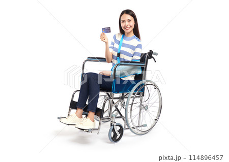 Beautiful young asian women with happy smiling and show credit card in a wheelchair on white background, healthcare concept, accident, insurance, life insurance, wellness, hospital. Beautiful young asian women with happy smiling and show credit card in a wheelchair on white background, healthcare concept, accident, insurance, life insurance, wellness, hospital. 114896457
