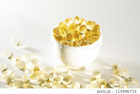 Transparent yellow vitamins on a light background. Vitamin D, omega 3, omega 6, Food supplement oil filled fish oil, vitamin A, vitamin E, flaxseed oil. 114896718