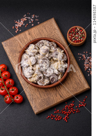 Boiled chicken hearts cut into slices with onions and cream sauce 114898387