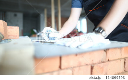 Male builder in yellow hard hat holds Male builder in yellow hard hat holds 114899598