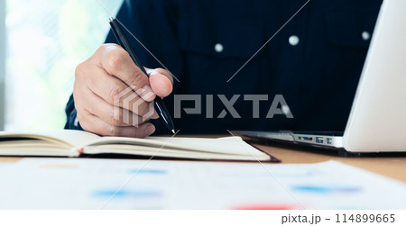 資料を見る男性の手元 114899665