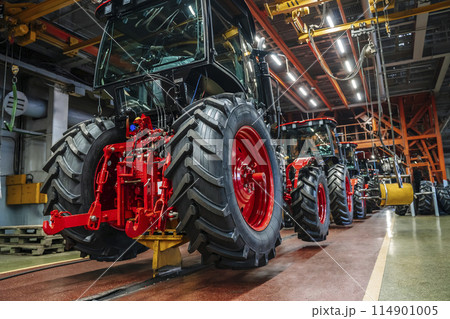 Tractor industry manufacture. New tractors on factory line. Production of agricultural machinery Tractor industry manufacture. New tractors on factory line. Production of agricultural machinery 114901005