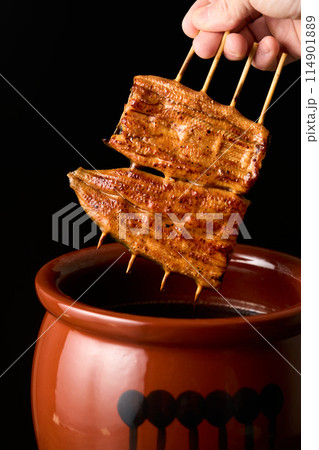 鰻の蒲焼をタレに漬ける 114901889