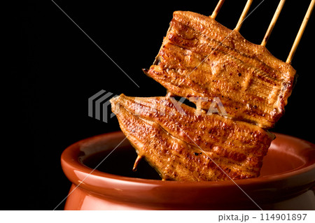 鰻の蒲焼をタレに漬ける 114901897