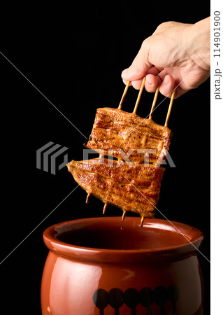 鰻の蒲焼をタレに漬ける 114901900