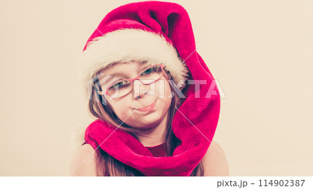 Girl in santa hat making silly face 114902387