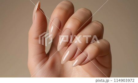 Closeup of woman hand with manicure with natural beige colored gel nail polish 114903972