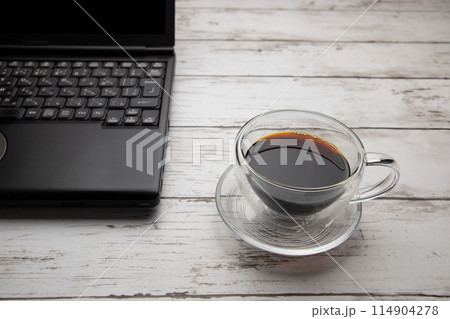 ガラス製のコーヒーカップとノートパソコン 114904278