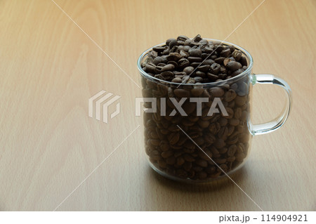 ガラス製コーヒーカップにぎっしり入ったコーヒー豆 114904921