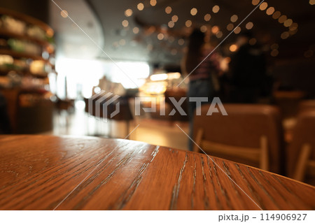 Empty wooden table top with lights bokeh on blur restaurant background 114906927
