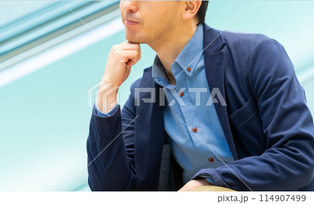 真剣な表情で考えごとをする男性ビジネスマン 114907499