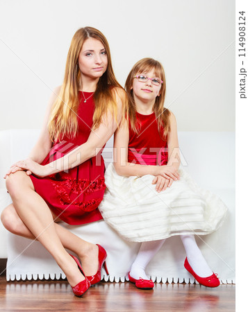 Mother and daughter posing together 114908124