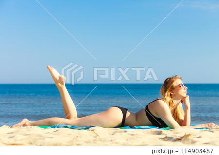 Summer vacation Girl in bikini sunbathing on beach Summer vacation Girl in bikini sunbathing on beach 114908487