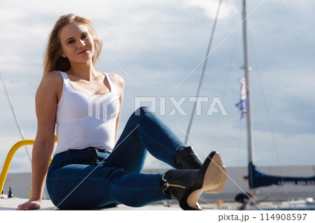 Woman sitting on marina Woman sitting on marina 114908597