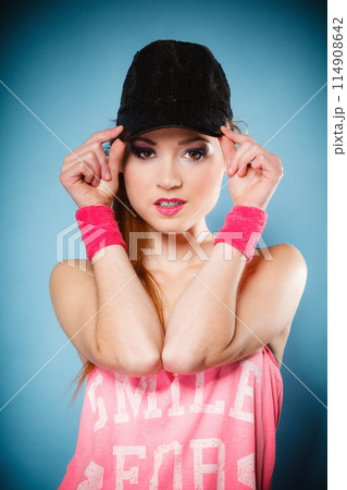 Sporty girl smiling in black baseball cap Sporty girl smiling in black baseball cap 114908642