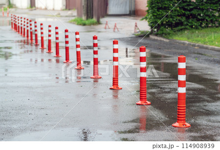 Road sign flexible plastic bollards with pedestrian white marking line and arrow sign on cement floor in parking car park area 114908939