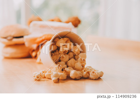 A bucket of popcorn, top-view, warm colors, light brown wooden background, flat lay, daylight macro close-up A bucket of popcorn, top-view, warm colors, light brown wooden background, flat lay, daylight macro close-up 114909236
