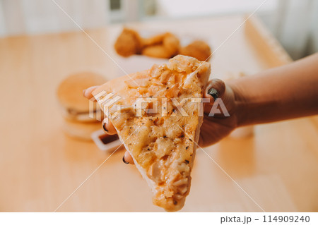 Cropped image of woman holding pizza slice at restaurant Cropped image of woman holding pizza slice at restaurant 114909240