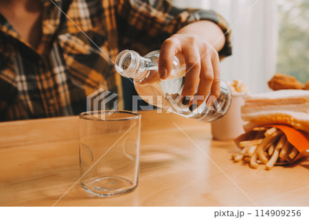 healthy beautiful young woman holding glass of water 114909256