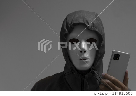 白い仮面をつけた男性とスマートフォン 114912500