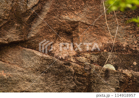 Dark red orange brown stone with cracks Closeup of uneven mountain surface Dark red orange brown stone with cracks Closeup of uneven mountain surface 114918957
