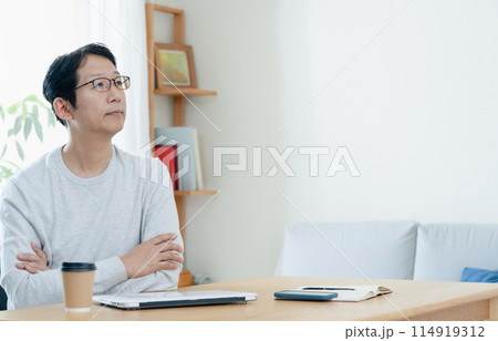リビングで考え込む男性 114919312