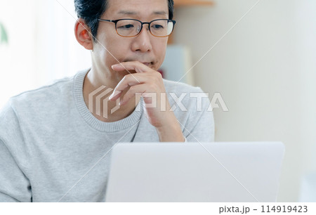 リビングで考え込む男性 114919423