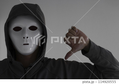 白い仮面をつけサムズダウンする男性 白い仮面をつけサムズダウンする男性 114920555