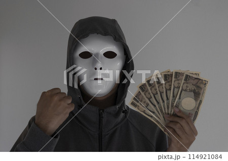白い仮面をつけお金を持つ男性。握りこぶし 114921084