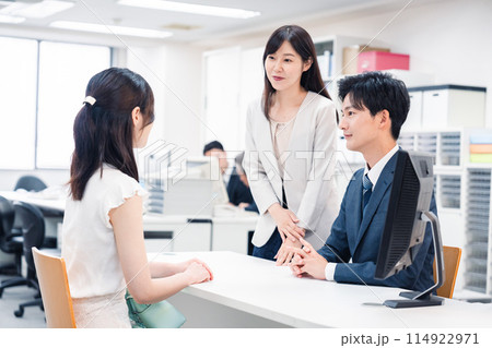 窓口で来客の対応をするビジネスパーソン 窓口で来客の対応をするビジネスパーソン 114922971