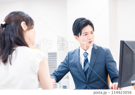 不動産会社のカウンターで相談をする若い女性 114923056