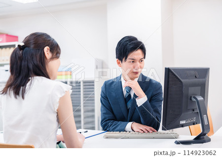 不動産会社のカウンターで相談をする若い女性 114923062