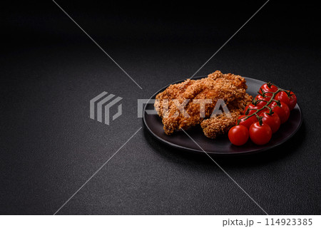 Delicious fresh crispy chicken nuggets on a dark concrete background Delicious fresh crispy chicken nuggets on a dark concrete background 114923385