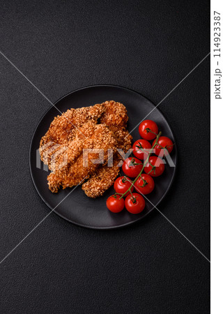 Delicious fresh crispy chicken nuggets on a dark concrete background Delicious fresh crispy chicken nuggets on a dark concrete background 114923387