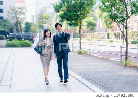 男女で外を歩くビジネスパーソン 男女で外を歩くビジネスパーソン 114923600