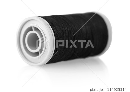 The bobbin with black thread on a white background 114925314