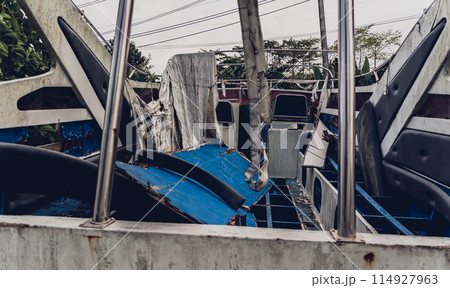 Old and rusty motor boats on a landfill surrounded by tropical forest 114927963